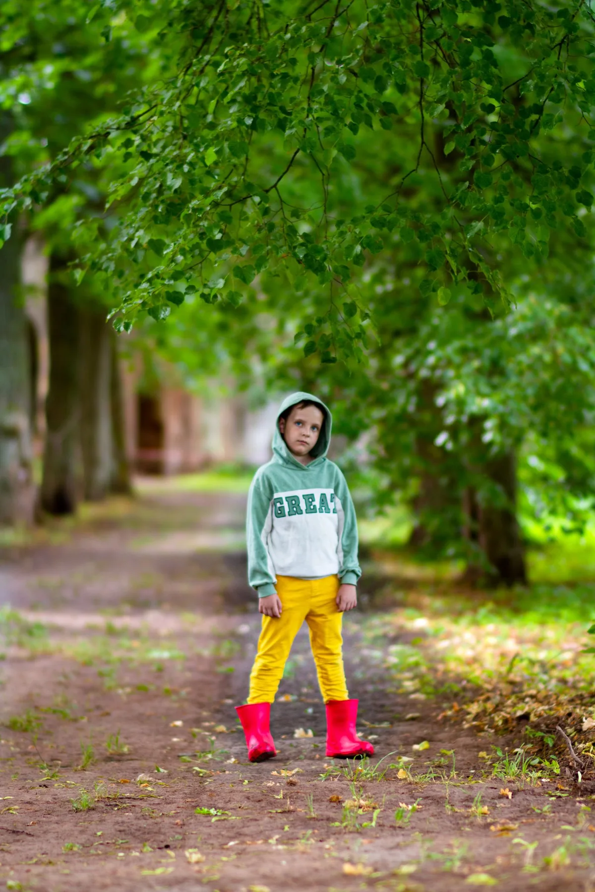 A child wearing red boots on a wooded path