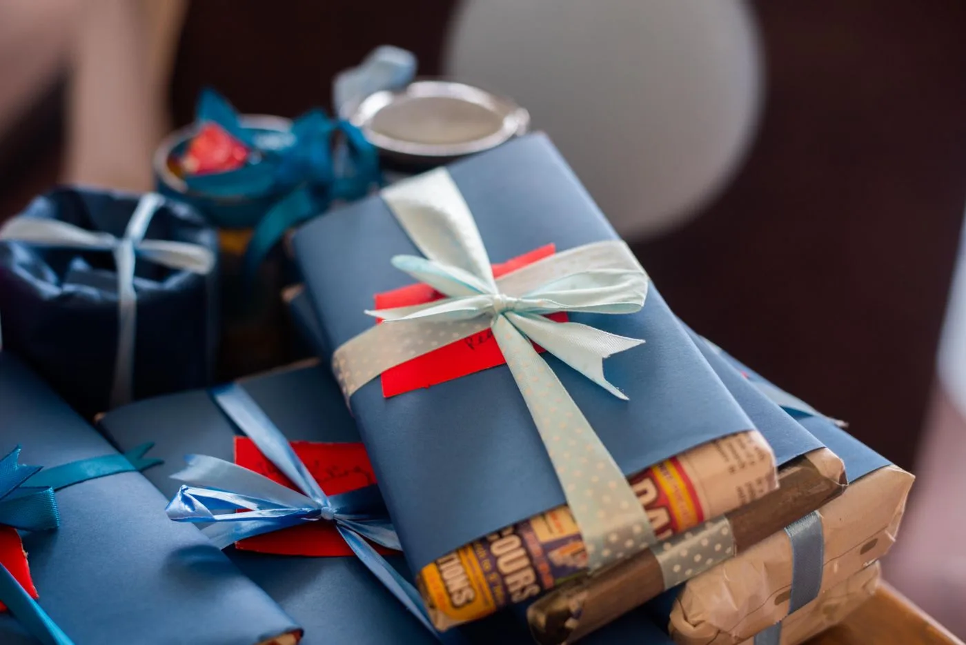 Stack of wrapped gifts tied with blue ribbons