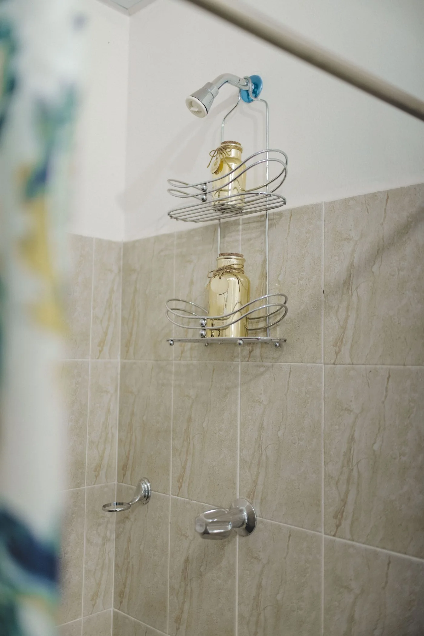 Shower shelves holding bottles against tiled walls.