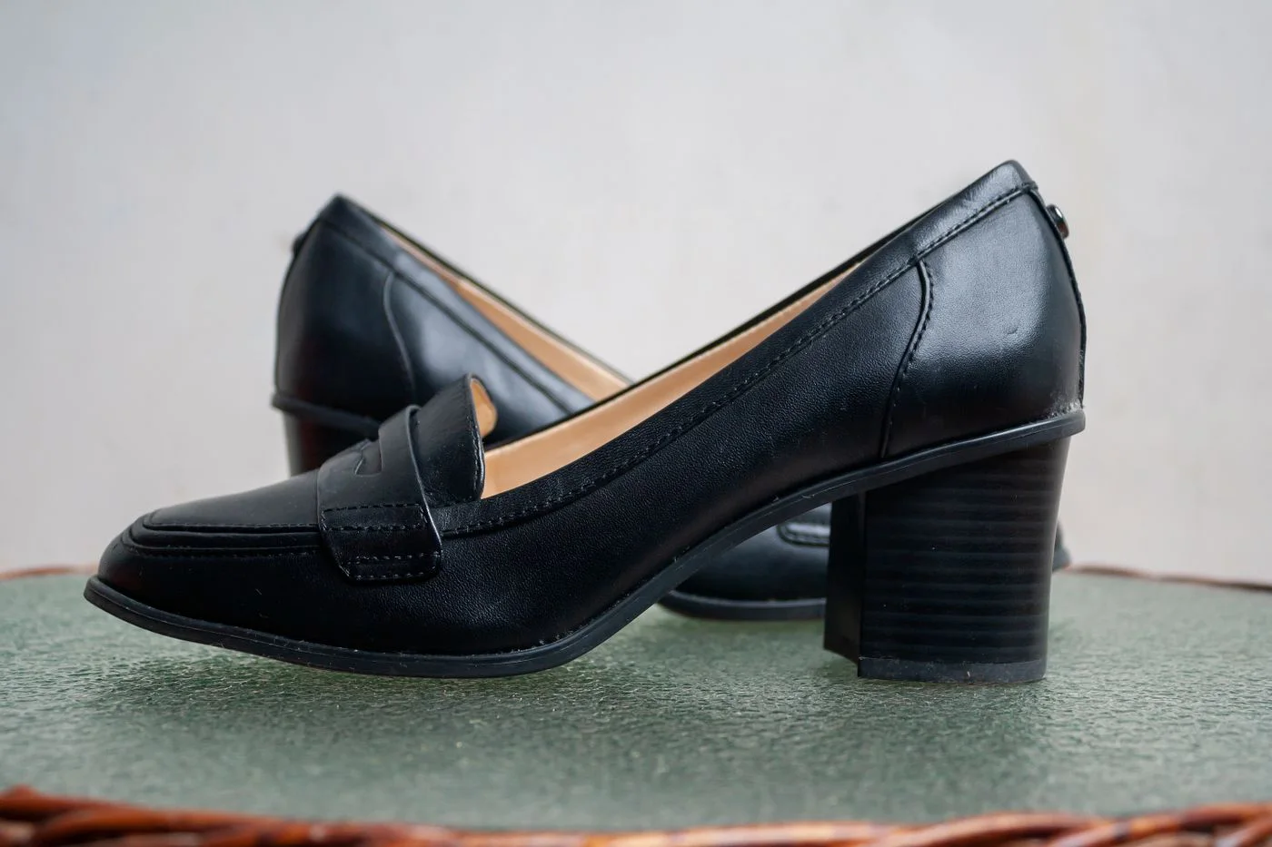 Black leather-looking slip-on shoes with low block heels.