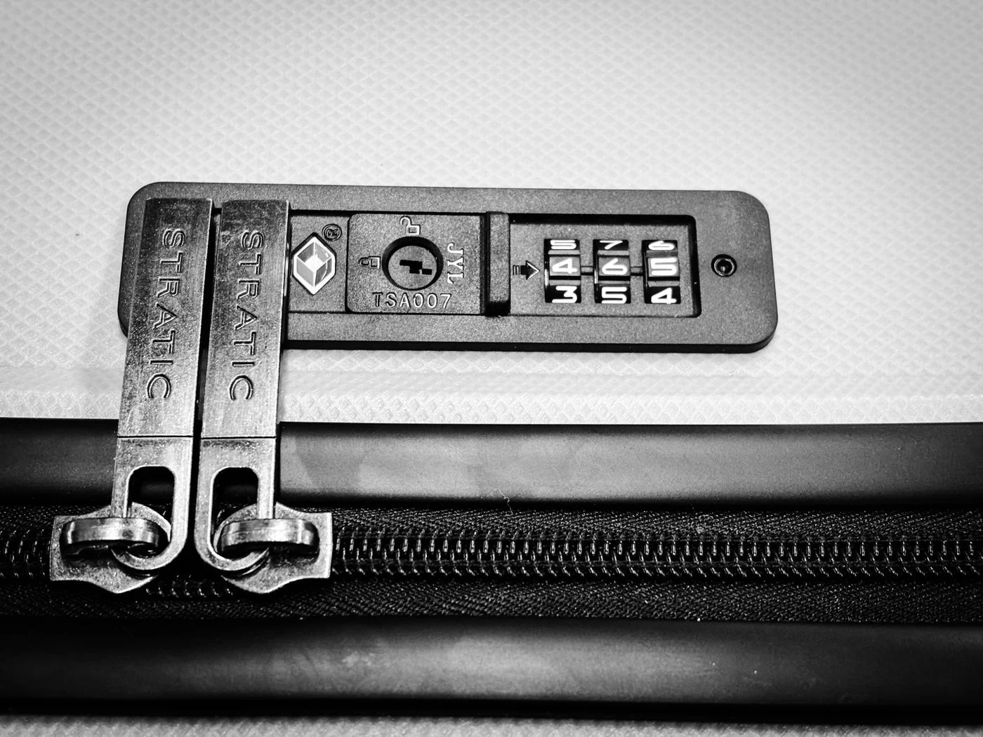 Close-up of a suitcase zipper and integrated lock.