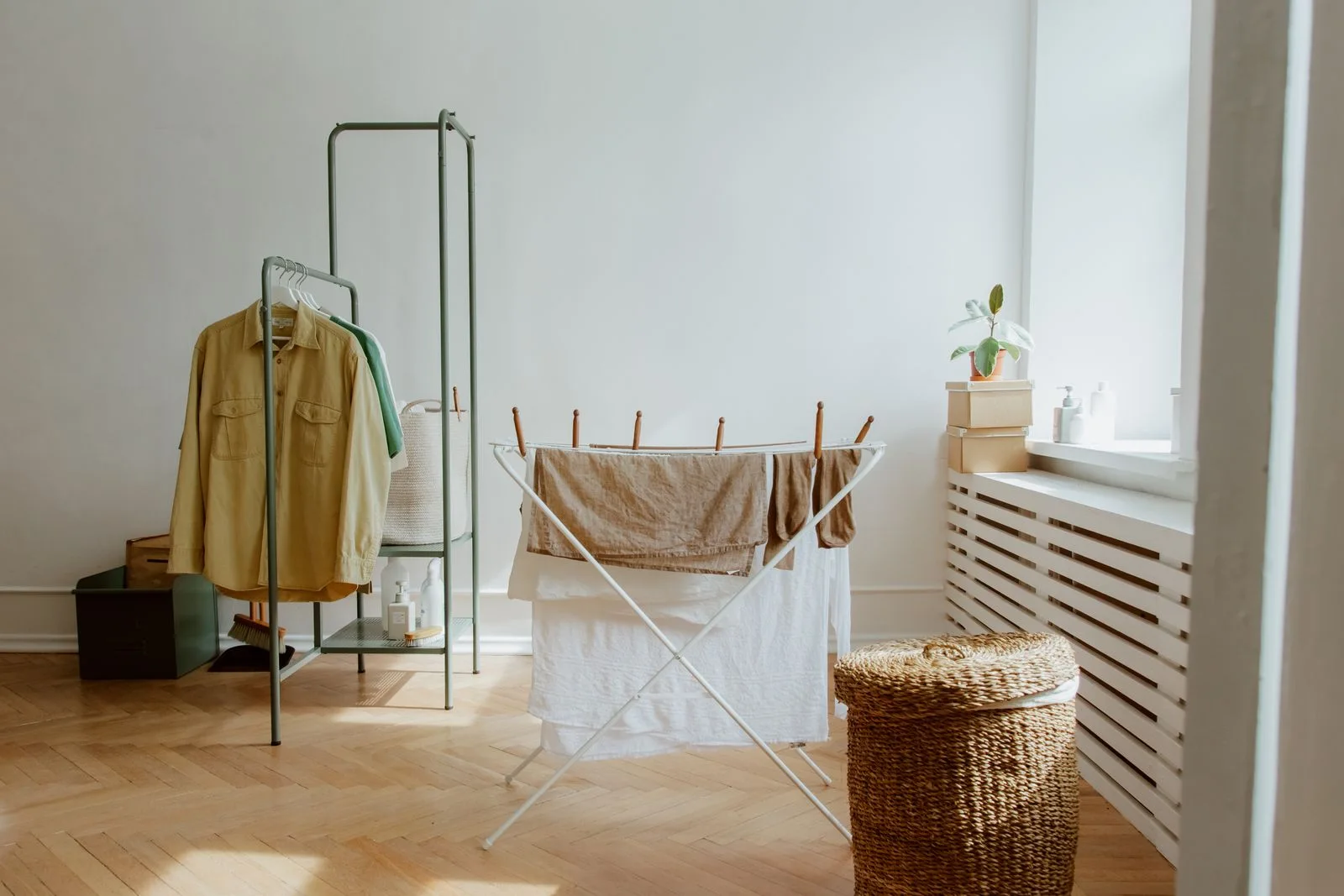 Clothing on a drying rack beside a window.