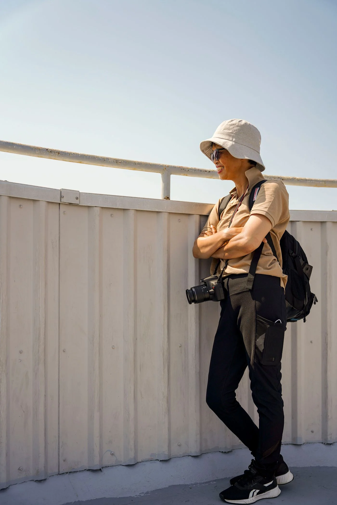 A traveler carrying a camera and backpack outdoors.