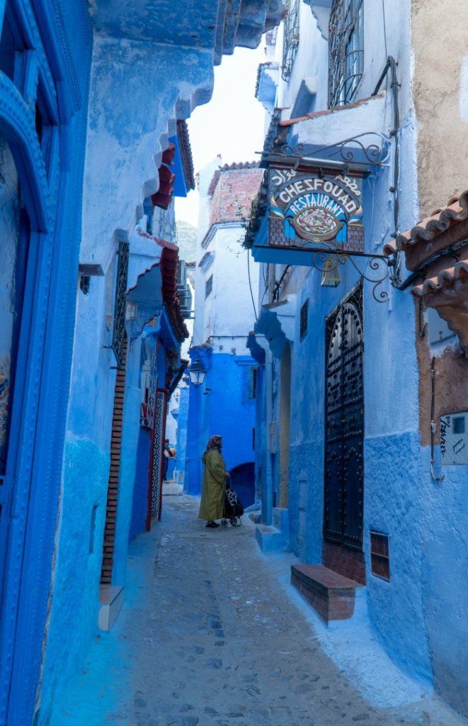 Women in blue street with Chezfouad Restaurant sign