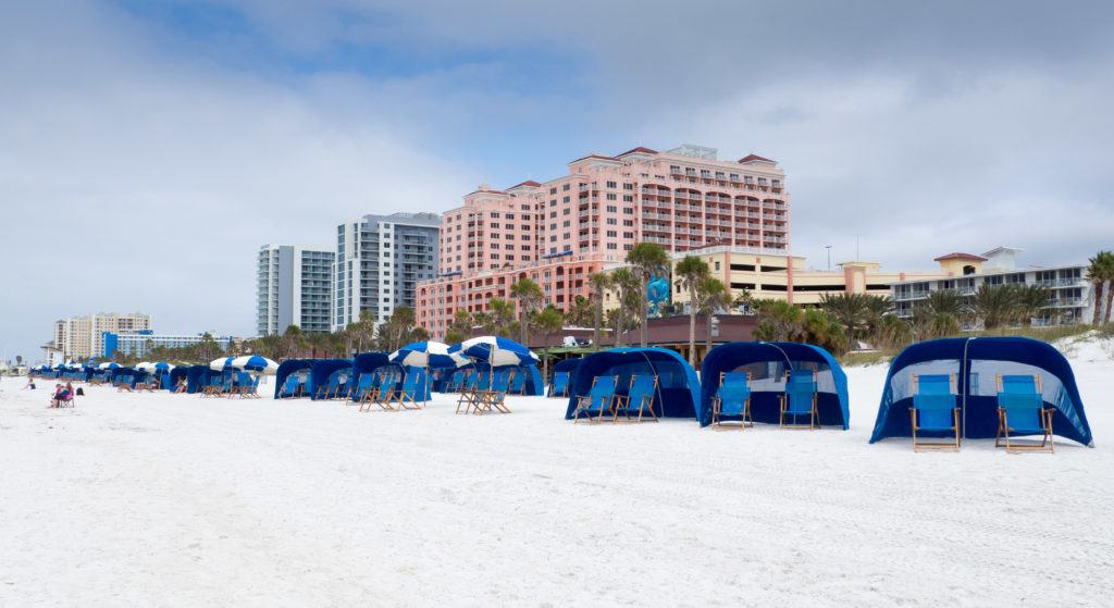 Blue beach cabanas in front of the pink Hyatt Regency Clearwater Beach