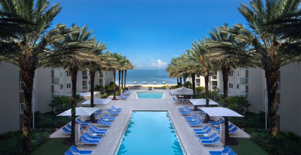 Edgewater Beach Hotel pool with palm trees and the beach in the distance