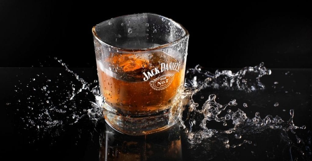 Jack Daniel's old No. 7 shot glass and splash (Canva)