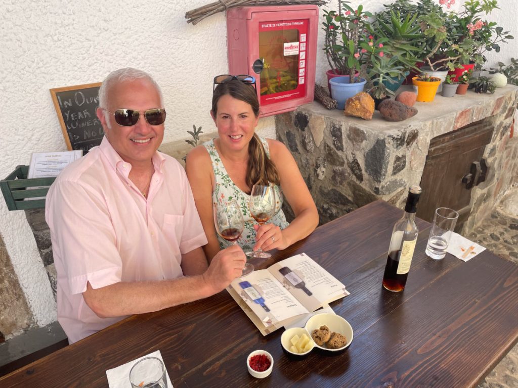 Couple holding wine glasses at wine tasting in Gavalas winery