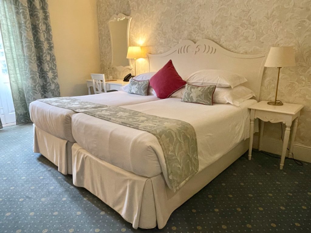Bed with white sheets and red pillow