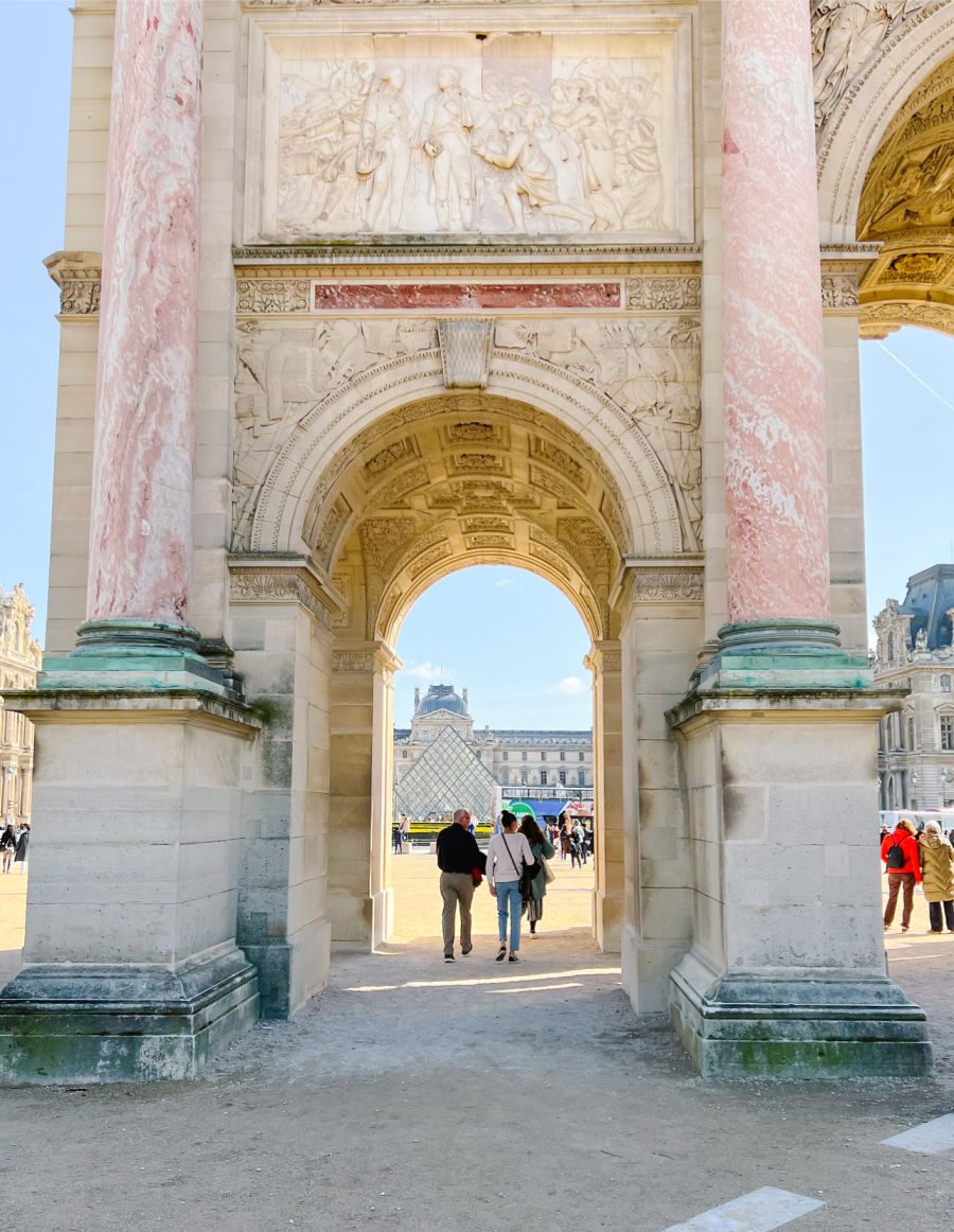 People walking through the Arc outside of the Louvre Museum