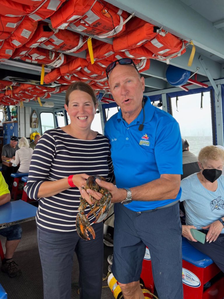 Tamara and Captain Ron holding lobster on the Lobster Tales boat cruise