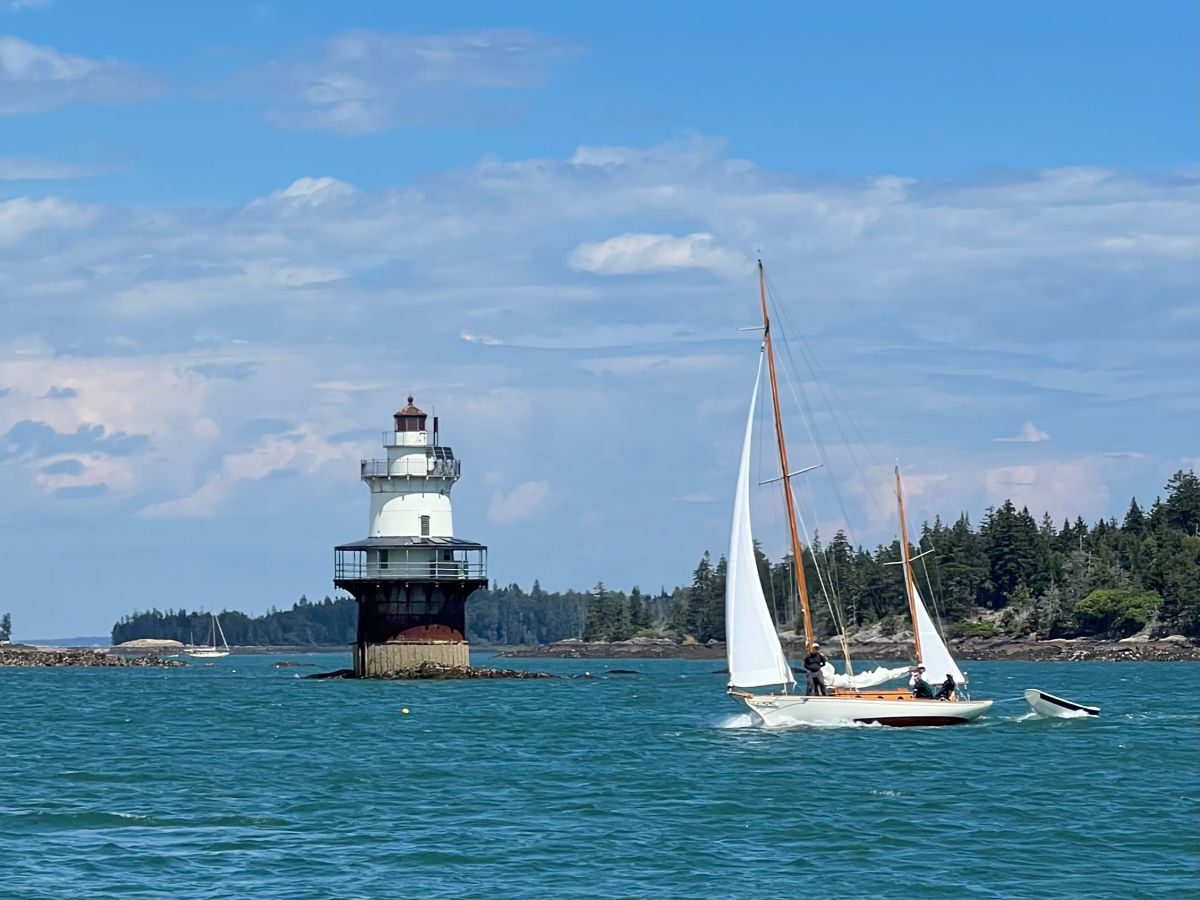 Goose Rocks lighthouse with a sailboat going past