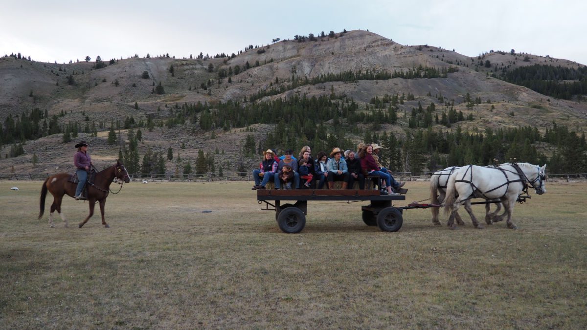 Group of people on a wagon being pulled by horses