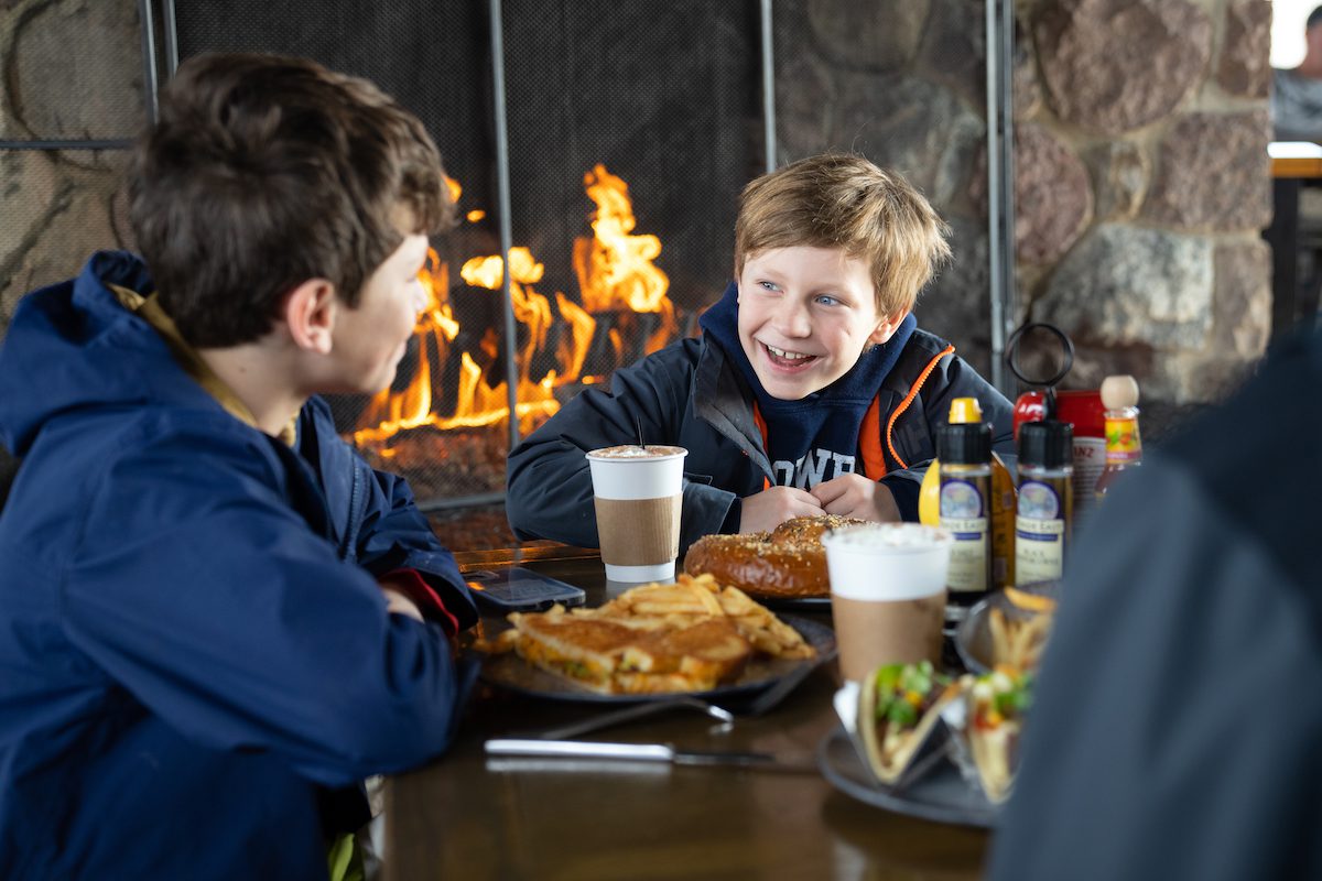 kids eating dinner in front of a fire