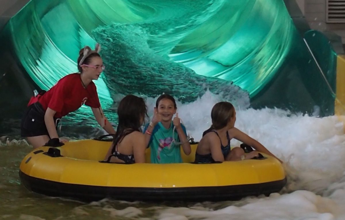 Girls in tube at bottom of water slide