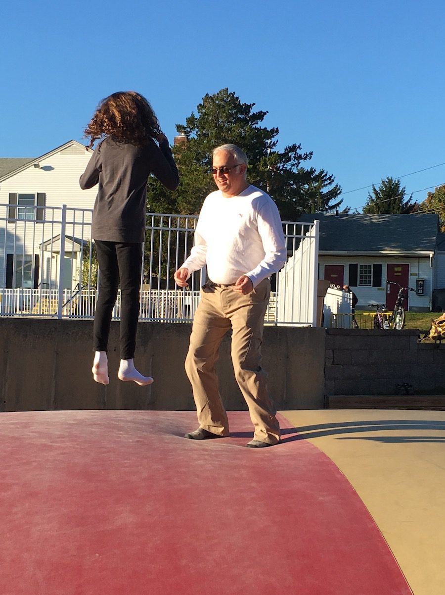 girl and dad jumping on jumping pillow at KOA Mystic
