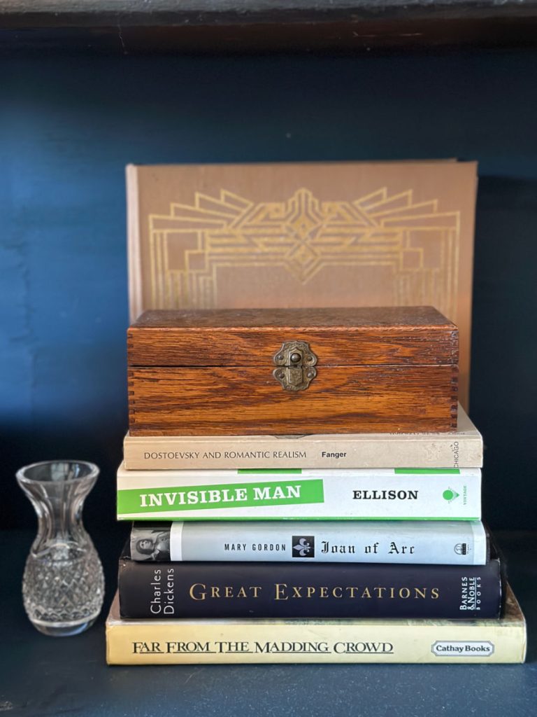 stack of books next to a vase