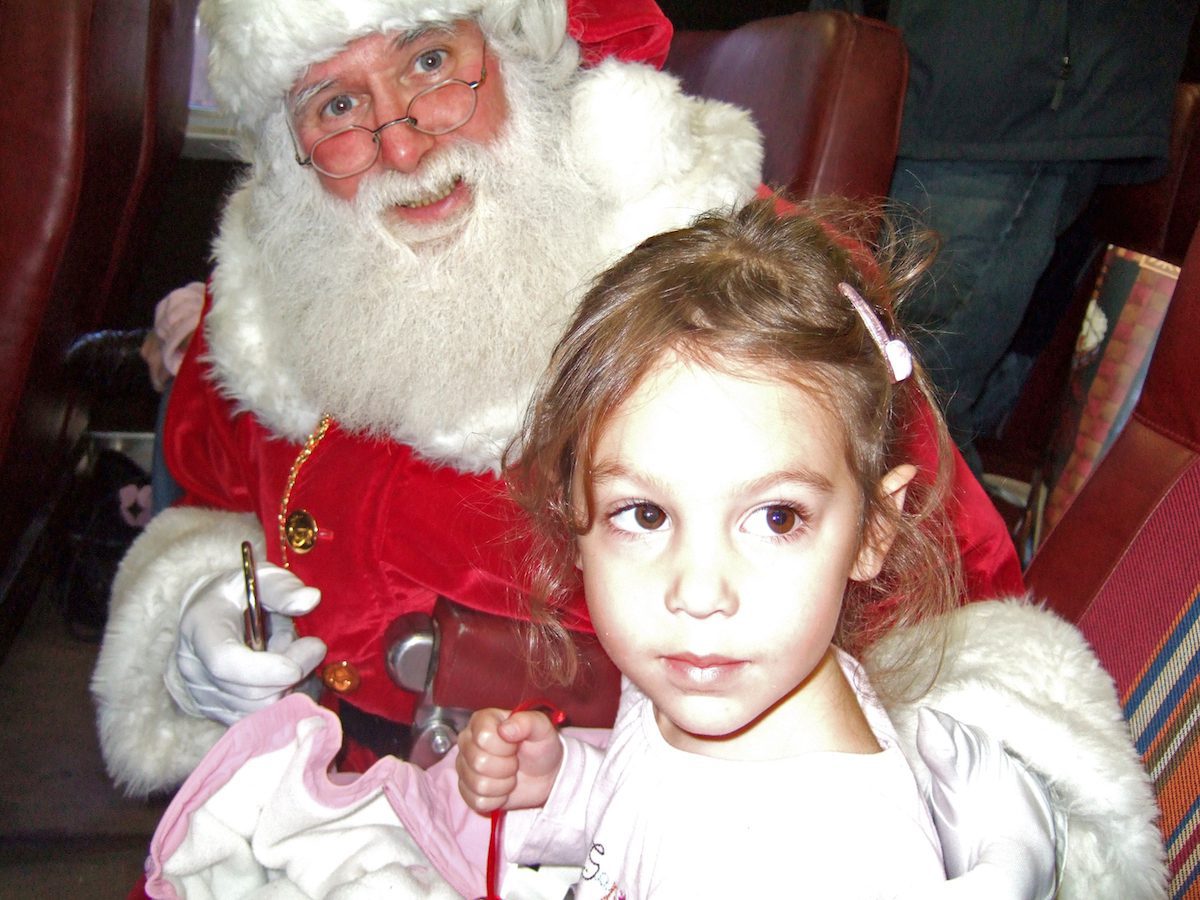 Girl holding bell with Santa on Polar Express
