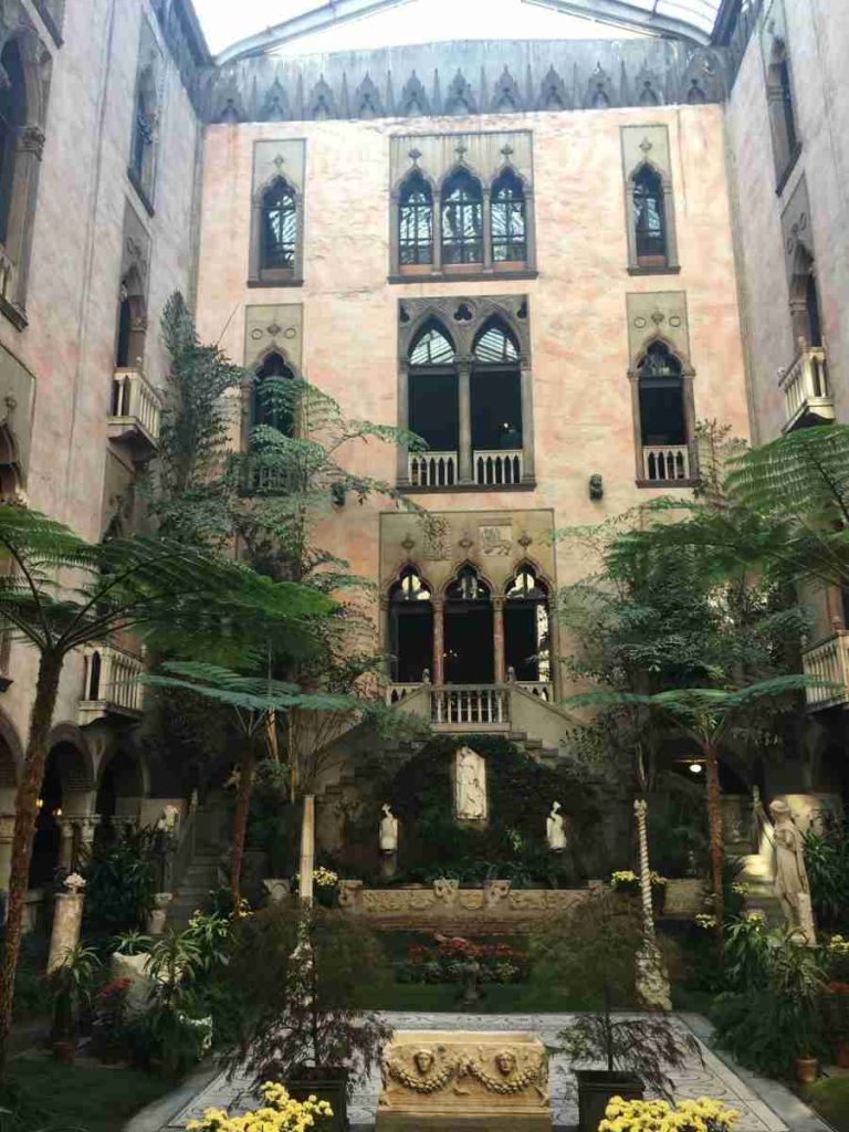 Courtyard with plants and beautiful architecture in the background.