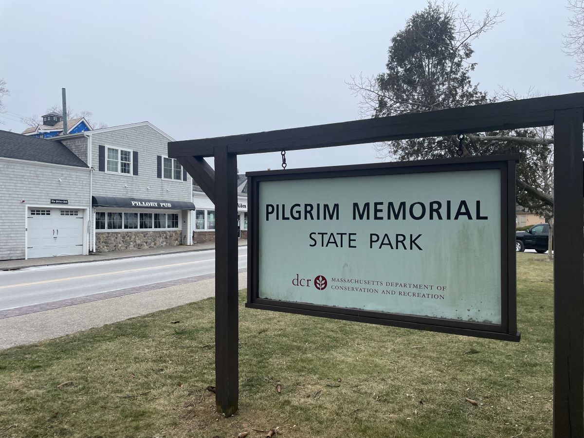 Entrance sign for park with pub in the background