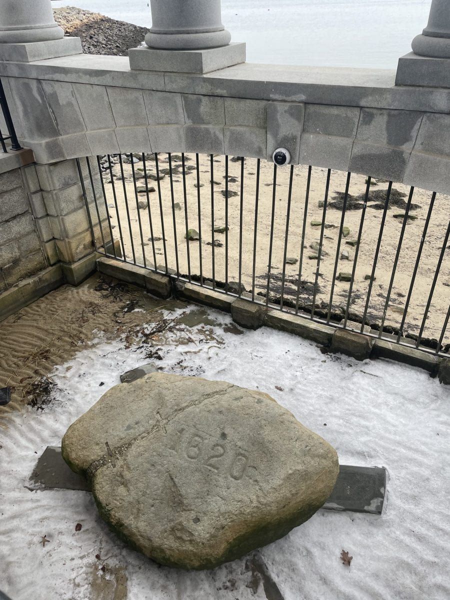 Caged in rock on the ground with the water in the background