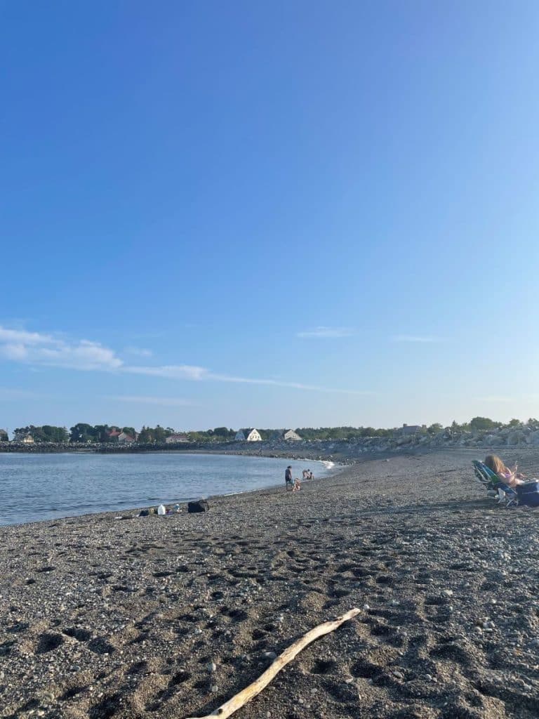rocky beach with few people and calm waters