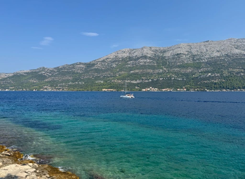 Boat on water off Korcula Croatia with mountains in the background
