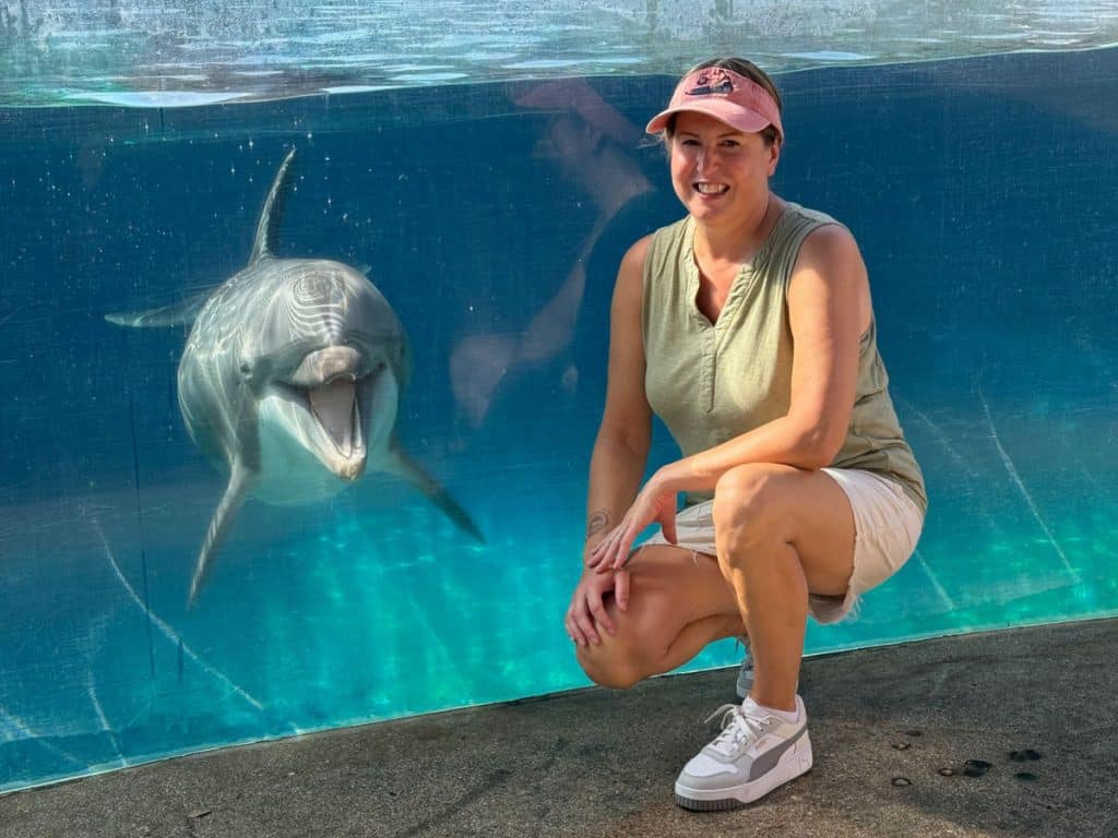 Tamara in front of dolphin pool with smiling dolphin