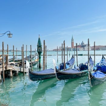 3 gondolas parked in the lagoon in venice