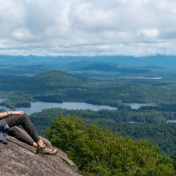 girl sitting on top of St Regis Mountain in the Adirondacks