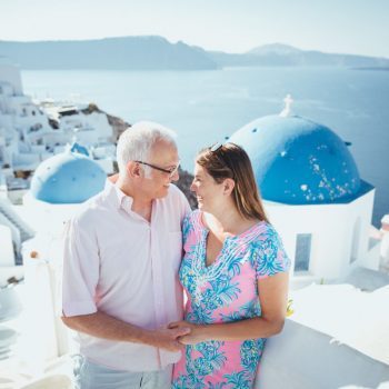 Couple in Oia Santorini with blue dome church in background